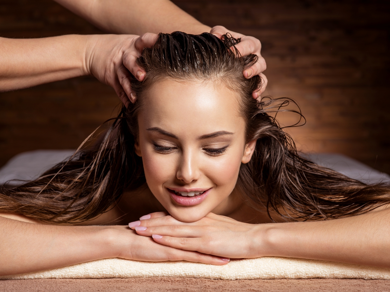 Masseur doing massage the head and hair for an woman in spa salon
